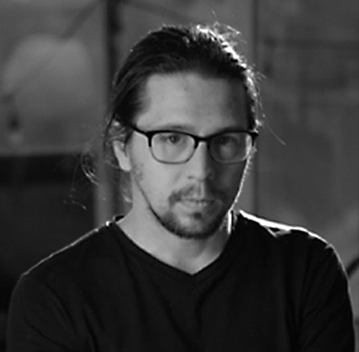 Black and white portrait of a person with glasses and a beard.